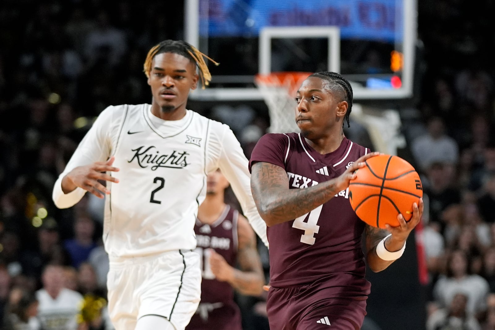 Texas A&M guard Wade Taylor IV (4) looks to pass the ball around Central Florida forward JJ Taylor (2) during the first half of an NCAA college basketball game, Monday, Nov. 4, 2024, in Orlando, Fla. (AP Photo/John Raoux)