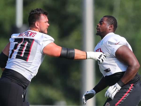 Falcons offensive lineman Jake Matthews (left) works with rookie offensive lineman Kion Smith on the fourth day of training camp Sunday, Aug. 1, 2021, in Flowery Branch. (Curtis Compton / Curtis.Compton@ajc.com)