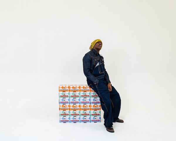 Lil Yachty poses standing against a stack of Yacht Water six-packs.