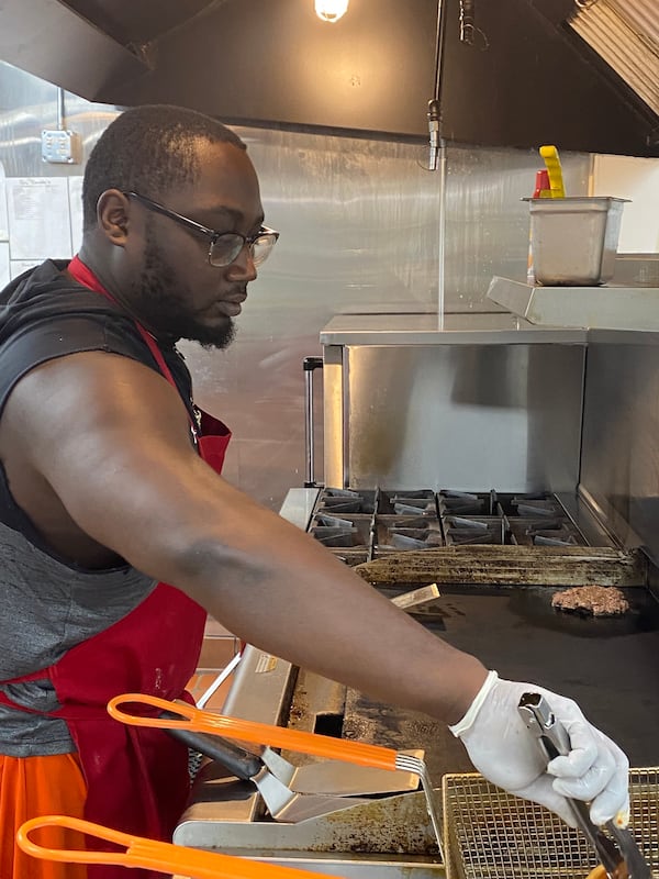 Jalen Mitchell, son of owner Conchitha Hargrove, operates the grill and fryer at VFC Kitchens, a virtual food court in Jonesboro. Ligaya Figueras/ligaya.figueras@ajc.com