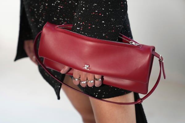 A model holds a handbag backstage as part of Courreges Fall/Winter 2025-2026 Womenswear collection presented Wednesday, March 5, 2025. in Paris. (Photo by Scott A Garfitt/Invision/AP)