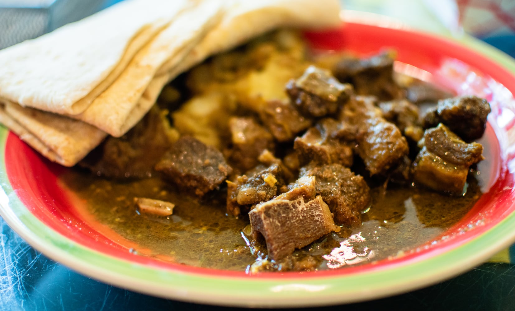 The bone-in curry goat combination meal with warm roti at Tassa Roti Shop in Marietta. CONTRIBUTED BY HENRI HOLLIS