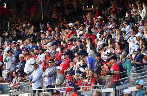 Braves fans stand during the first inning of the first game at 100% seating capacity at Truist Park on Friday, May 7, 2021, in Atlanta.  (Hyosub Shin / Hyosub.Shin@ajc.com)