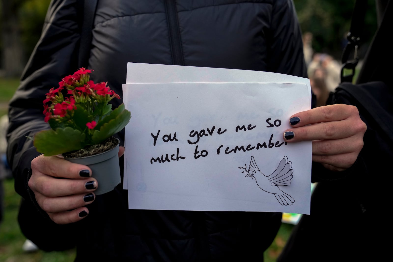 A fan holds a message as fans gather to pay tribute to late British singer Liam Payne, former member of the British pop band One Direction in Treptower Park in Berlin, Germany, Sunday, Oct. 20, 2024. (AP Photo/Ebrahim Noroozi)