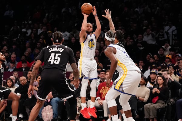 Golden State Warriors' Stephen Curry (30) shoots over Brooklyn Nets' Keon Johnson (45) during the second half of an NBA basketball game Thursday, March 6, 2025, in New York. (AP Photo/Frank Franklin II)