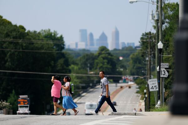 People cross Buford Highway during midday on Monday, Aug. 14, 2023. The actual high temperature reached 97 degrees, and the heat index was in the triple digits. (Miguel Martinez/miguel.martinezjimenez@ajc.com)



