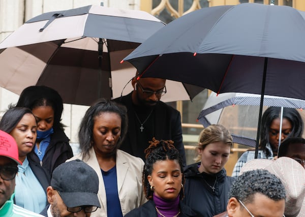 People bow their heads in prayer during a press conference held by the Concerned Black Clergy of Metropolitan Atlanta at City Hall. Faith leaders and members of the community spoke out against the violent demonstrations at the Atlanta Public Safety Training Center site known as ‘Cop City’ on Friday, March 10, 2023. (Natrice Miller/ Natrice.miller@ajc.com)