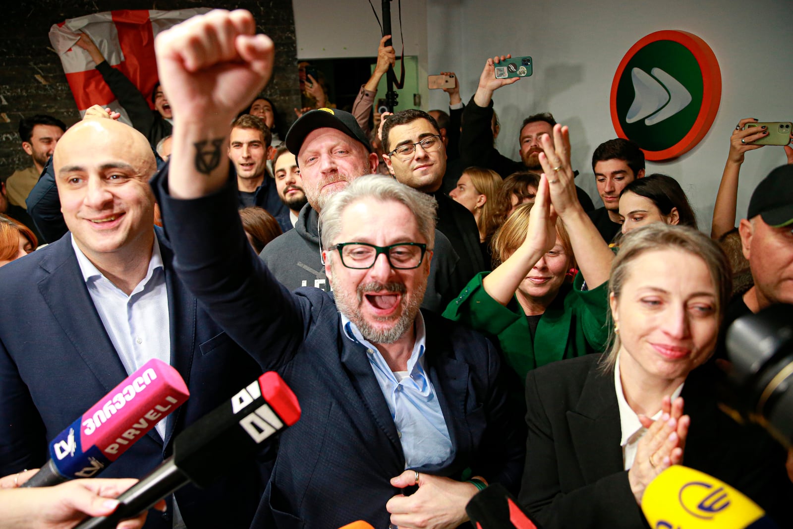 From left, Nika Melia, Nika Gvaramia, leaders of Coalition for Changes, and Nana Malashkhia, who leads the Coalition for Change parliament list, react while talking to journalists at coalition's headquarters after polls closing at the parliamentary election in Tbilisi, Georgia, Saturday, Oct. 26, 2024. (AP Photo/Zurab Tsertsvadze)