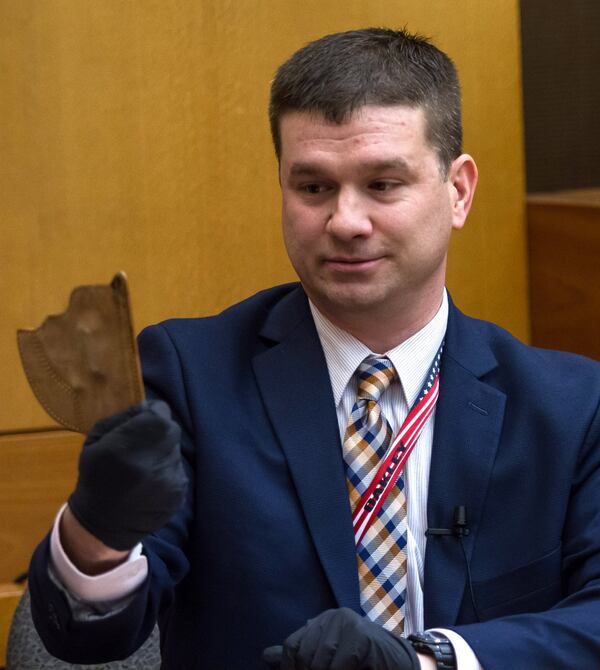 Detective Darrin Smith holds up a holster on day 14 of the Tex McIver murder trial at the Fulton County Courthouse on Friday, March 30, 2018. STEVE SCHAEFER / SPECIAL TO THE AJC