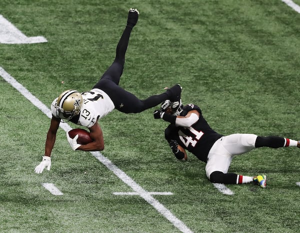 Saints wide receiver Michael Thomas picks up yardage on a catch and is sent flying by Atlanta Falcons safety Sharrod Neasman during the fourth quarter Sunday, Dec. 6, 2020, at Mercedes-Benz Stadium in Atlanta. (Curtis Compton / Curtis.Compton@ajc.com)