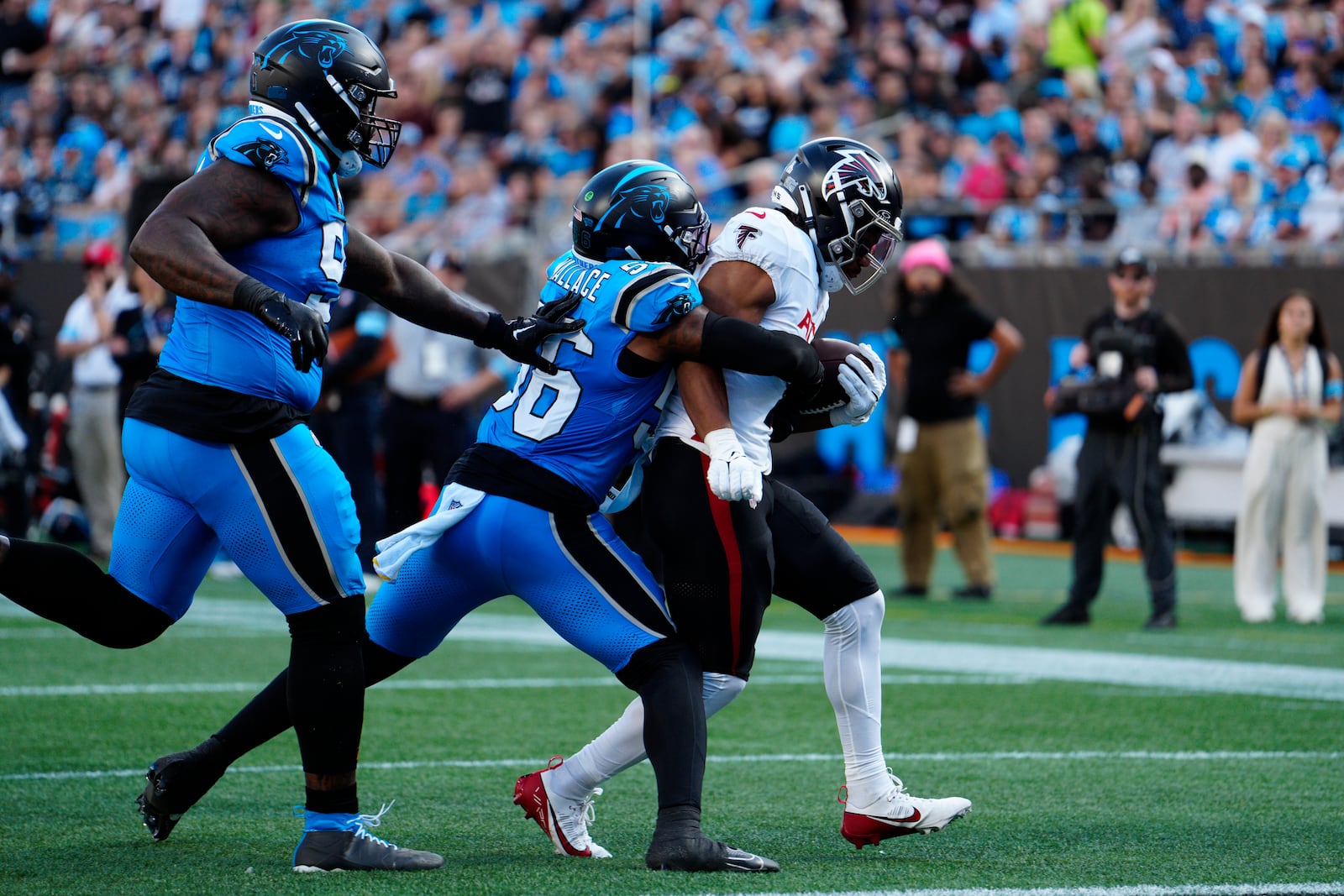 Atlanta Falcons running back Bijan Robinson (7) runs in a touchdown against Carolina Panthers linebacker Trevin Wallace (56) in the first half of an NFL football game against in Charlotte, N.C., Sunday, Oct. 13, 2024. (AP Photo/Jacob Kupferman)