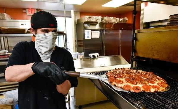 Jonathon Turner makes a pizza at Don’s Pizza on Central Avenue Wednesday, April 29 in Middletown. Don’s Pizza is open for carryout and delivery while the dining room is closed due to coronavirus pandemic. NICK GRAHAM/STAFF