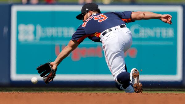 Houston Astros shortstop Jack Mayfield dives for a ground ball single by New York Mets' Michael Conforto during the third inning of a spring training baseball game Saturday, Feb. 29, 2020, in West Palm Beach, Fla. (Jeff Roberson/AP)