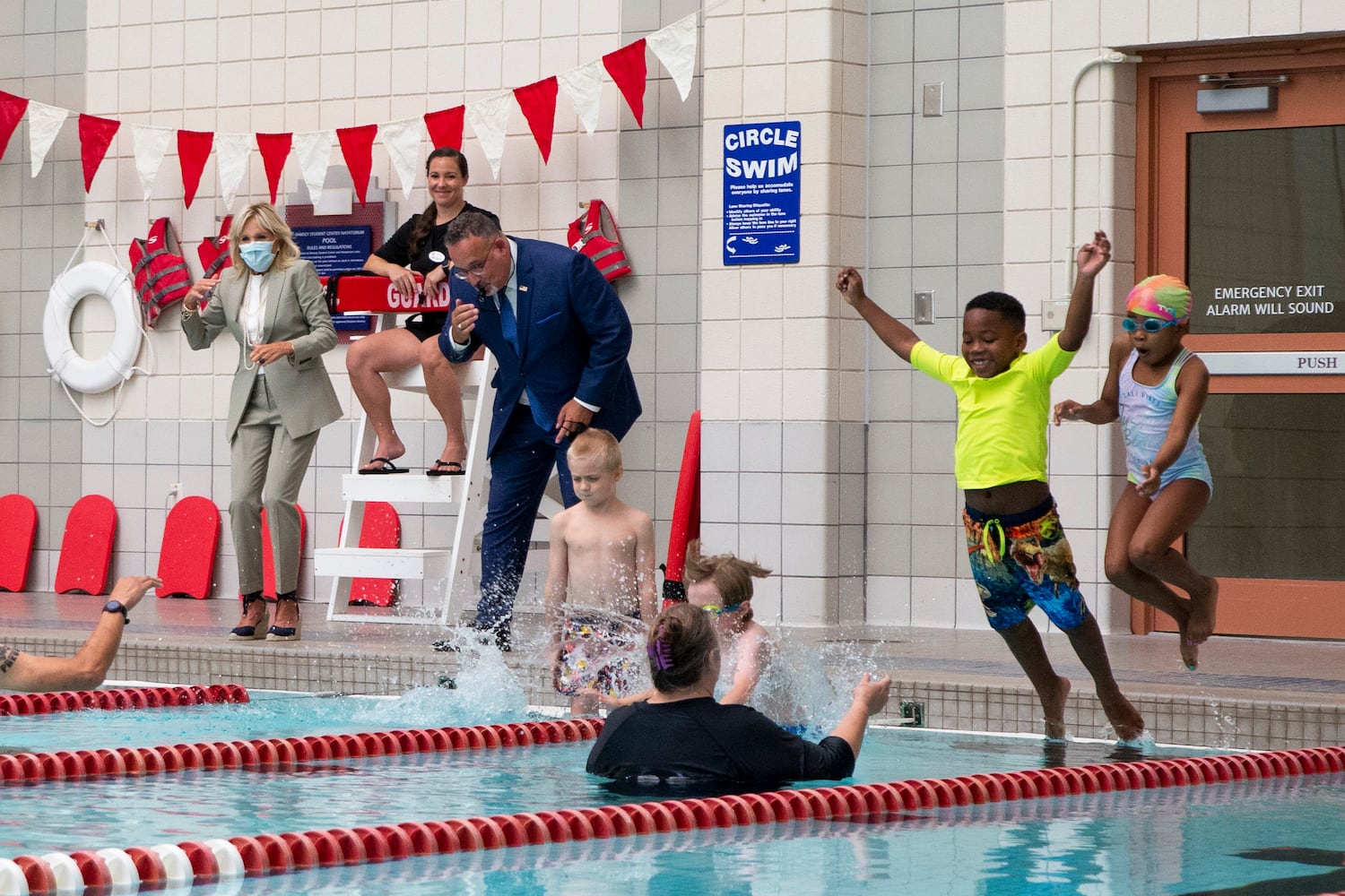 First Lady Jill Biden laughs as Education Secretary Miguel Cardona blows a whistle and students jump into a pool for a swimming lesson while the two visit a Horizons Atlanta summer learning program at the University of Georgia in Athens, Georgia, on Thursday, July 21, 2022. The program serves students from Barnett Shoals Elementary School and has units on English, math and swimming. (Chris Day/Christopher.Day@ajc.com)