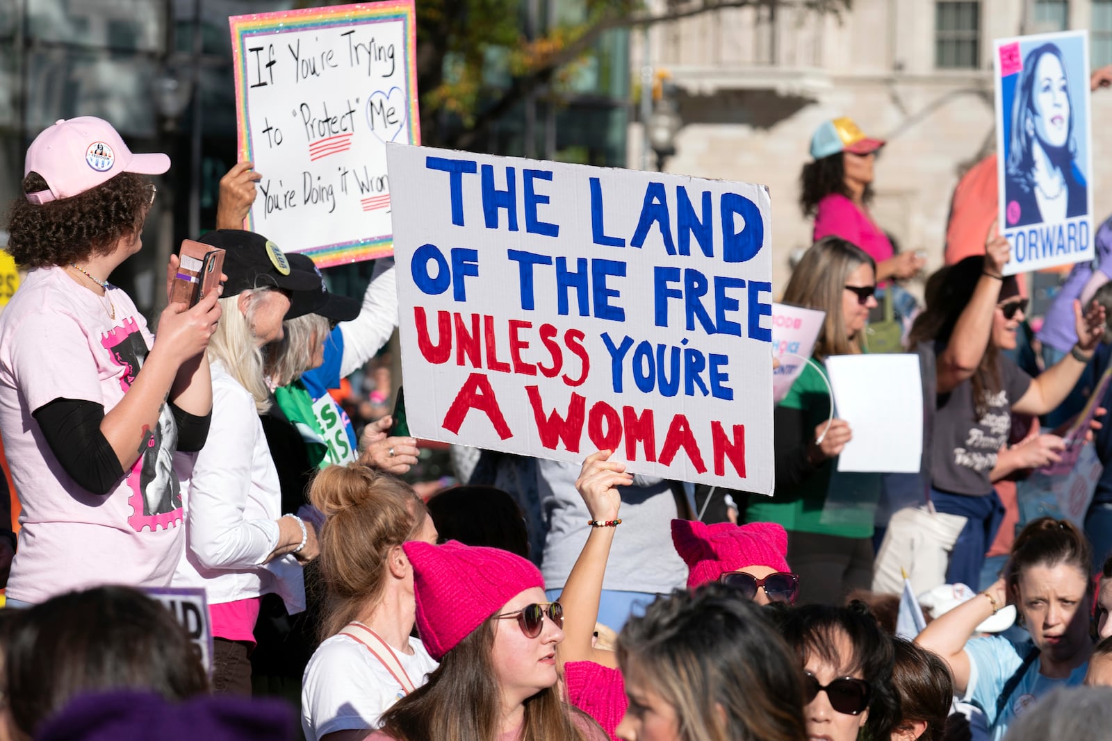 Demonstrators hold up signs during the national Women's March at Freedom Plaza in Washington, Saturday, Nov. 2, 2024. (AP Photo/Jose Luis Magana)