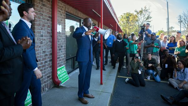 U.S. Sen. Raphael Warnock, center, campaigns Tuesday in Savannah with U.S. Sen. Jon Ossoff, left, a fellow Georgia Democrat. Warnock has spent much of the campaign reaching for voters in the middle. He has talked more during the campaign about partnering on legislation with Republicans such as Texas U.S. Sen. Ted Cruz than working with Democratic President Joe Biden. (AJC Photo/Stephen B. Morton)