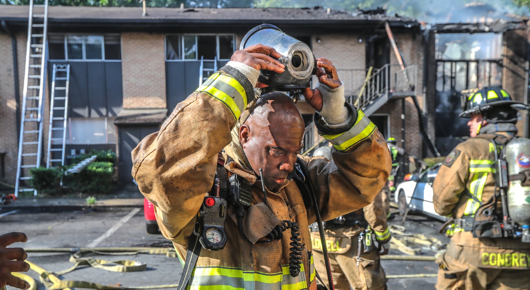 July 7, 2022 Atlanta: Atlanta firefighters had a hot morning battling an apartment blaze in the 2200 block of Campbellton Road in Atlanta on Thursday, July 7, 2022. The call came in at 9 am for the Adams House Apartments where units arrived to heavy smoke conditions according to Atlanta Fire Rescue Captain Taurus Durrah. Flames erupted from the bottom floor to the top floor and then the attic Durrah said. Crews initially had to bring in tank water to get water on the fire because of the 800 foot distance to the hydrant on Campbellton Road. Four units were damaged and 8-families displaced. No one was injured and the fire is under investigation. Durrah said more units are being sent to fire scene to shorten the rotation of fire crews due to the heat. Firefighters are told to hydrate  and stay cool a full shift before coming to work to combat the heat. (John Spink / John.Spink@ajc.com)


