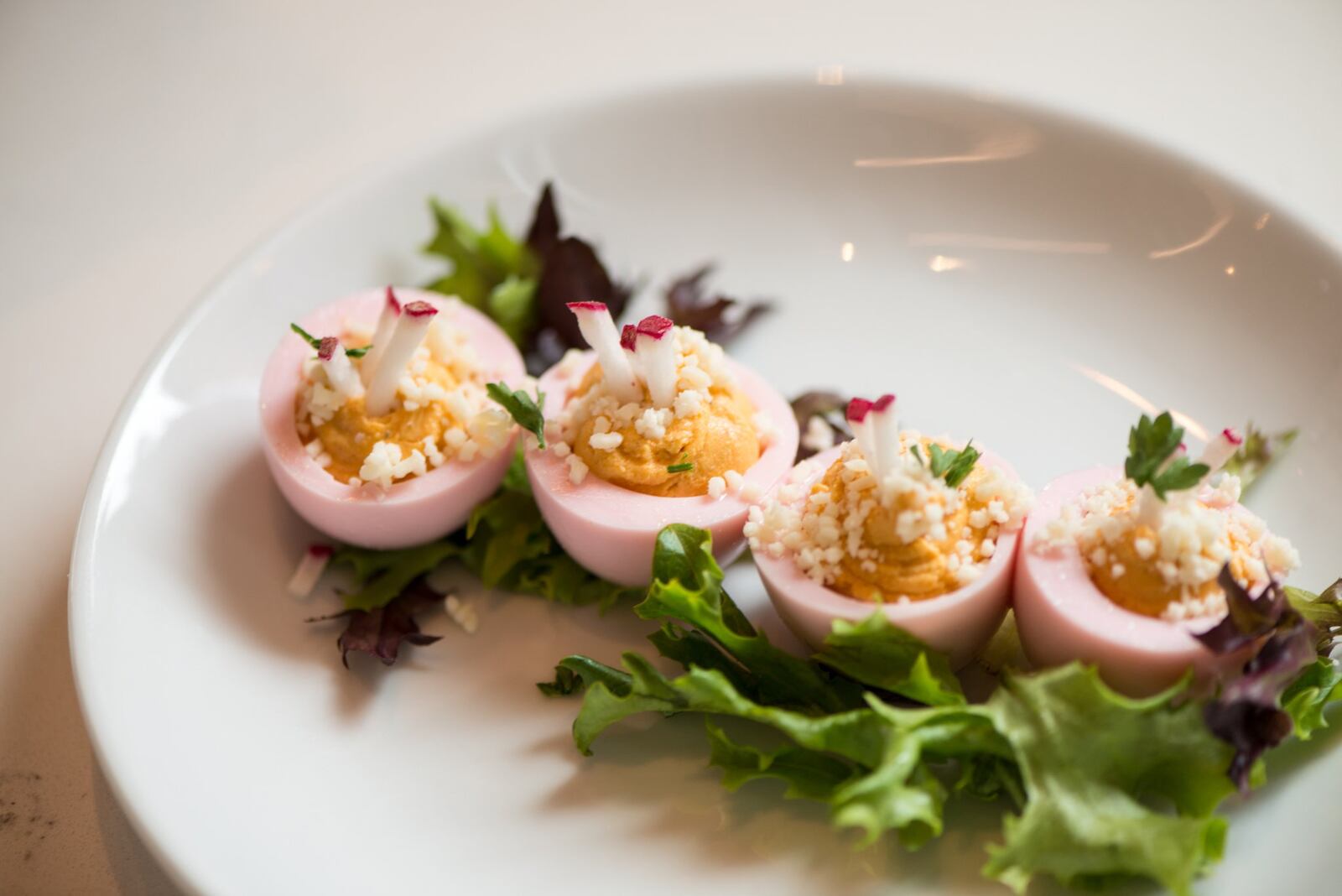 Full Commission Pink Deviled Eggs with beet wash, cotija cheese, and radish. Photo credit- Mia Yakel.