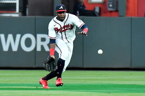 A ball hit by Los Angeles Dodgers center fielder Chris Taylor falls in front Braves center fielder Guillermo Heredia, scoring two runs, during the seventh inning of Game 2 of the NLCS Sunday, Oct. 17, 2021, at Truist Park in Atlanta. (Hyosub Shin / Hyosub.Shin@ajc.com)