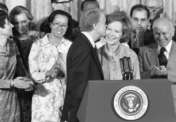 Jimmy Carter kisses Rosalynn Carter during ceremony in which he receives the Final Report of the President's Commission on Mental Health. April 27, 1978. (White House Staff Photographer / Jimmy Carter Library)