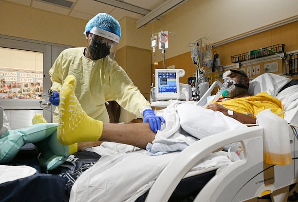 Dr. Erine Raybon-Rojas checks her patient infected with COVID-19 in Northeast Georgia Medical Center's Intensive Care Unit on Wednesday. (Hyosub Shin / Hyosub.Shin@ajc.com)