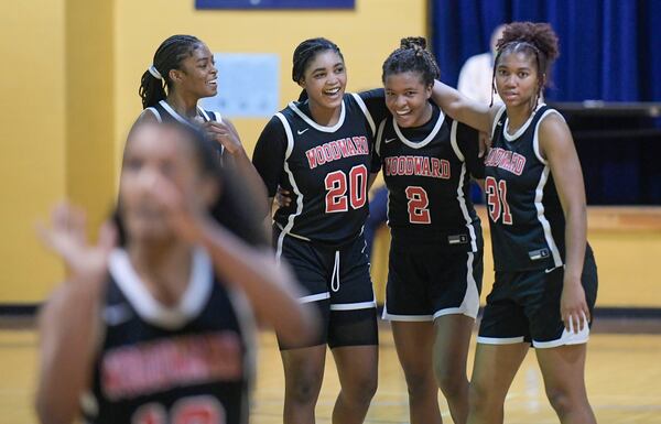 Woodward’s Savannah Simms (5, from left), Zoe Scott (20), Sara Lewis (2), and Sydney Bowles (31) celebrate their lead over Southwest DeKalb as teammate Kai Lanier (foreground) shoots a foul shot late in the half of their Class 5A state quarterfinal game Tuesday, March 2, 2021, at Southwest DeKalb High. (Daniel Varnado/For the AJC)