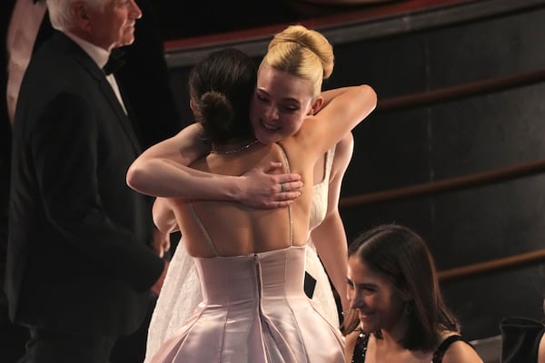 Monica Barbaro, left, embraces Elle Fanning in the audience during the Oscars on Sunday, March 2, 2025, at the Dolby Theatre in Los Angeles. (AP Photo/Chris Pizzello)