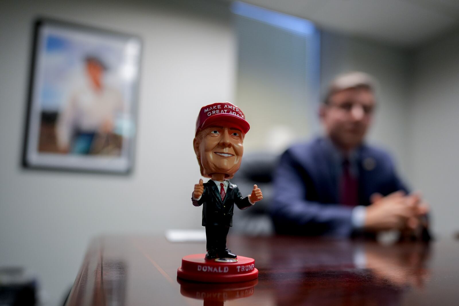 A bobblehead of Republican presidential nominee former President Donald Trump sits on the desk as Speaker of the House Mike Johnson, R-La., speaks during an interview with The Associated Press at the Lucas County Republican Party headquarters in Holland, Ohio, Saturday, Oct. 26, 2024. (AP Photo/Carolyn Kaster)