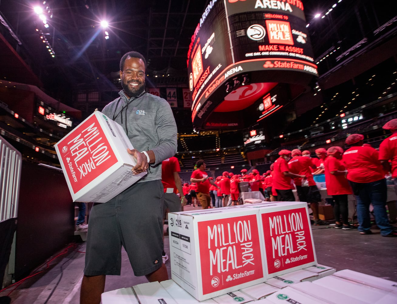 Chris Gilchrist, with US Hunger, puts boxes of red lentil jambalaya meal kits on pallets for local food banks.  (Jenni Girtman for The Atlanta Journal-Constitution)