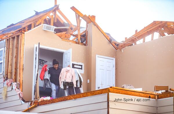 Marta Correa brings out her daughter’s clothing from a closet. A tornado blew off the side of the bedroom. JOHN SPINK / JSPINK@AJC.COM