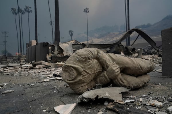 A statue and other structures are burned as the Palisades Fire ravages a neighborhood amid high winds in the Pacific Palisades neighborhood of Los Angeles, Wednesday, Jan. 8, 2025. (AP Photo/Damian Dovarganes)