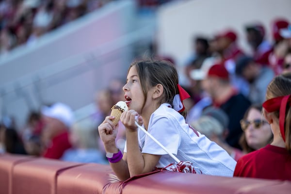 Adele Zoghby, of Mobile, Ala., enjoys an ice cream cone during the first half of an NCAA college football game between Mercer and Alabama, Saturday, Nov. 16, 2024, in Tuscaloosa, Ala. (AP Photo/Vasha Hunt)