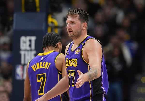 Los Angeles Lakers guard Luka Doncic is congratulated after hitting a basket and drawing a foul in the second half of an NBA basketball game against the Denver Nuggets, Saturday, Feb. 22, 2025, in Denver. (AP Photo/David Zalubowski)