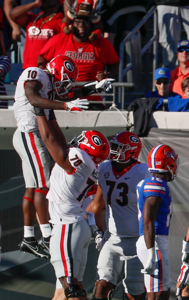 10/30/21 - Jacksonville -  Georgia Bulldogs wide receiver Kearis Jackson (10) is lifted by Georgia Bulldogs offensive lineman Warren McClendon (70) after his TD catch )during the first half of the annual NCCA  Georgia vs Florida game at TIAA Bank Field in Jacksonville.   Bob Andres / bandres@ajc.com