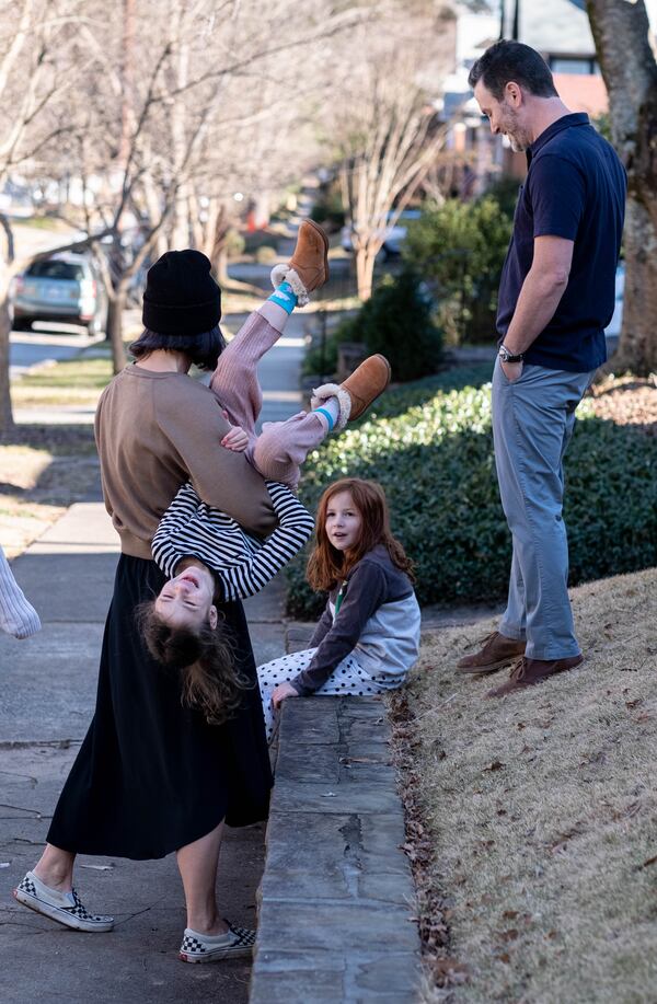 210115-Atlanta-Jennifer Holdbach flips her daughter Laly, 6, over while her and her husband Evan Cohn talk to one of their other daughters Etta, 8, Friday, Jan. 15, 2021 at their home in Virginia-Highland.  Ben Gray for the Atlanta Journal-Constitution