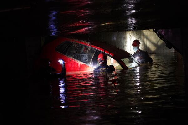 Civil Guards check cars for bodies in an indoor car park after floods in Paiporta, near Valencia, Spain, Monday, Nov. 4, 2024. (AP Photo/Alberto Saiz)