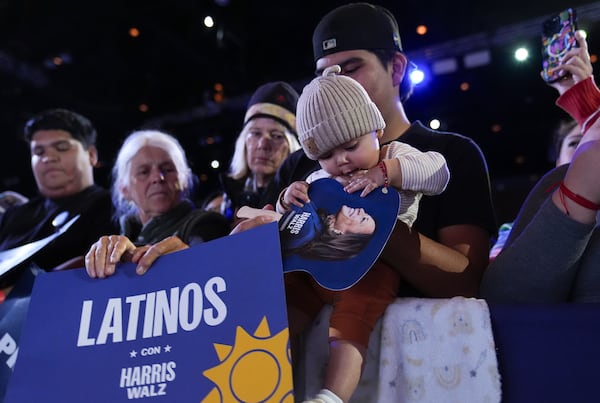 FILE - A child chews on their shirt as supporters hold signs and listen to Democratic presidential nominee Vice President Kamala Harris speak in Reno, Nev., Oct. 31, 2024. (AP Photo/Susan Walsh, File)