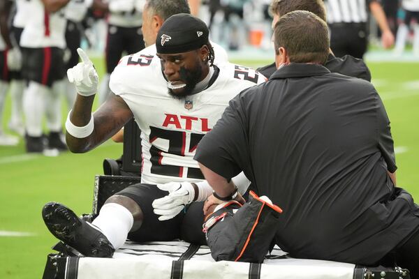 Atlanta Falcons safety DeMarcco Hellams (23) is assisted off the field during the first half of a pre season NFL football game against the Miami Dolphins, Friday, Aug. 9, 2024, in Miami Gardens, Fla. (AP Photo/Wilfredo Lee)