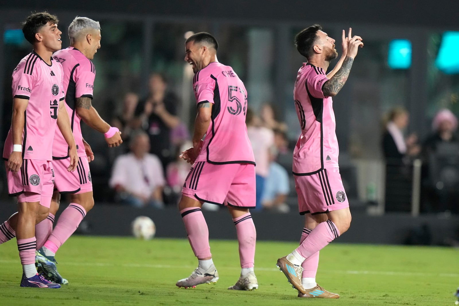 Inter Miami forward Lionel Messi, right, reacts after scoring his third goal for a hat trick during the second half of an MLS soccer match against the New England Revolution, Saturday, Oct. 19, 2024, in Fort Lauderdale, Fla. (AP Photo/Lynne Sladky)