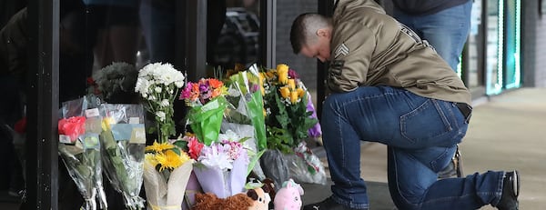 U.S. Army veteran Latrelle Rolling pauses to pray after dropping off flowers at Youngs Asian Massage.