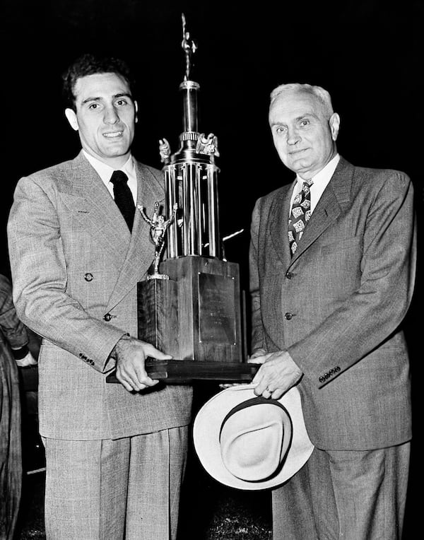 Charley Trippi, right, of the University of Georgia, receives a trophy for most valuable player in the 1945 All-Star  game from Bernie Bierman, right, who coached the 1945 All-Stars, Aug. 23, 1946, in Chicago.  (AP Photo)