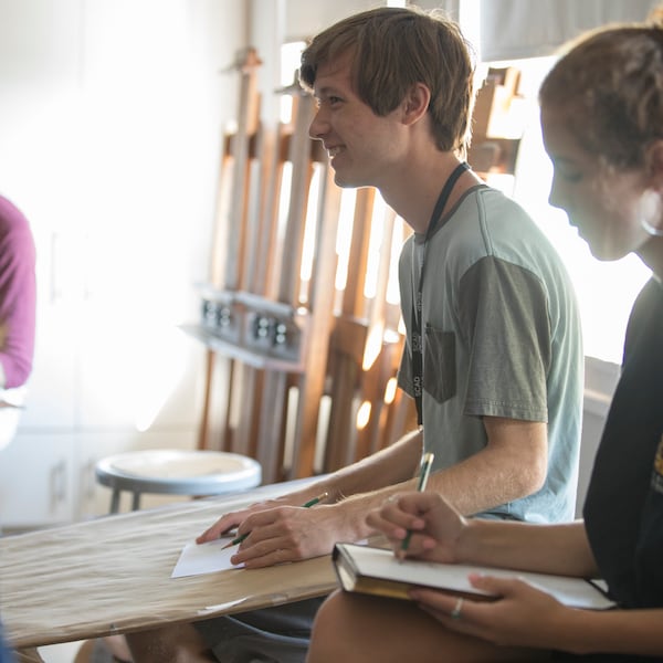 A student takes notes during a lecture in a SCAD workshop.