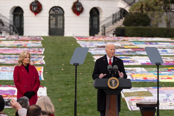 President Joe Biden speaks as first lady Jill Biden listens on the South Lawn of the White House during a ceremony to commemorate World AIDS Day with survivors, their families and advocates, Sunday, Dec. 1, 2024, in Washington. (AP Photo/Manuel Balce Ceneta)