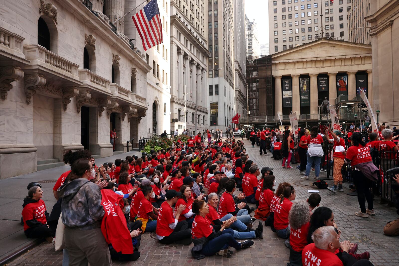 Anti-Israel protesters occupy an area in front of the New York Stock Exchange, left, Monday, Oct. 14, 2024. (AP Photo/Yuki Iwamura)