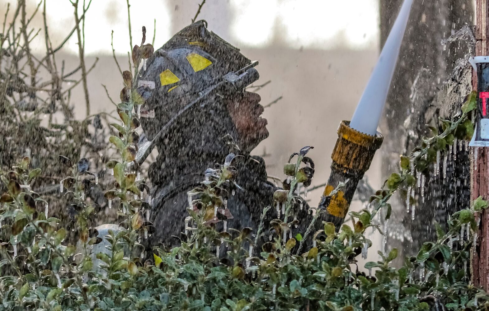 Atlanta firefighter, Coleman Lynn is surrounded by icicles that formed on a bush in arctic temperatures Wednesday morning, Jan. 17, 2024 where a fire destroyed an abandoned house in northwest Atlanta, according to officials. Crews were dispatched around 8 a.m. to the vacant one-story home in the 600 block of Jett Street near Sunset Avenue, according to Atlanta fire Capt. Raymondo Hampton. Firefighters took a defensive attack on the fully involved residence until they could get to a point where they could conduct a search inside. No one was found during the search. “We were able to get a good stop on it pretty quick,” Hampton told The Atlanta Journal-Constitution. While the cause and origin of the fire is under investigation, Hampton said he suspects it was just people trying to stay warm. “It’s cold temperatures outside right now, we’re at about 14 degrees,” he said. The low temps were an obstacle for firefighters, who Hampton said typically bring extra equipment and clothes during similar operations as a precaution. He noted it was the second time fire crews responded to the home in recent months. No injuries were reported Wednesday. (John Spink / John.Spink@ajc.com)