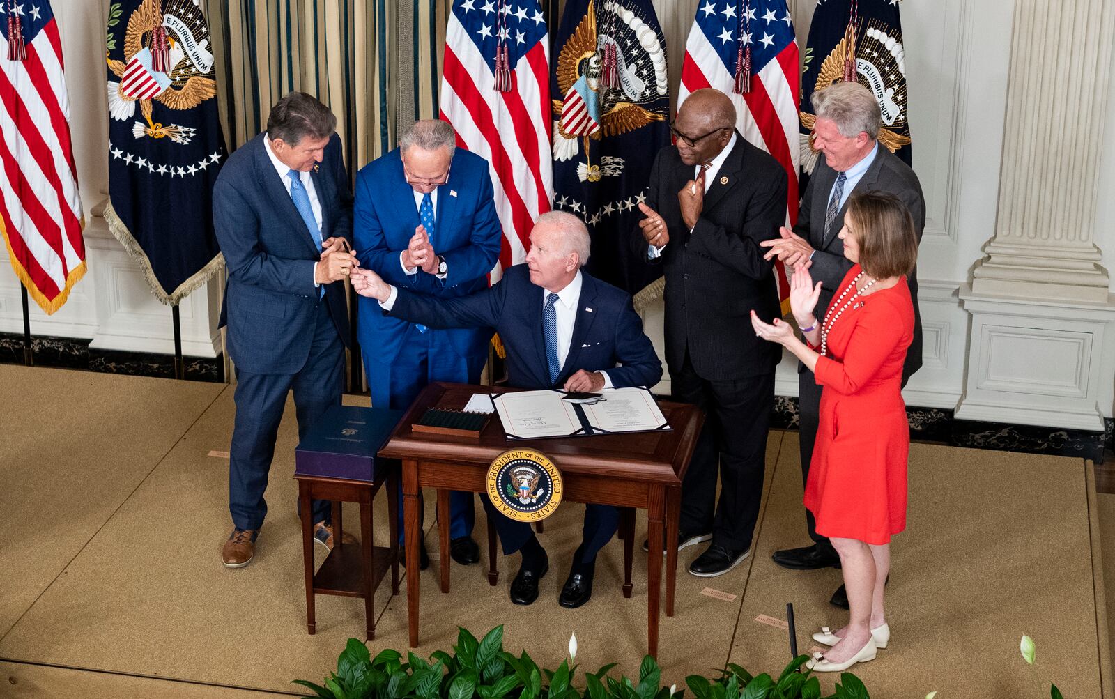 President Joe Biden hands a pen to U.S. Sen. Joe Manchin, D-W.Va., after signing into law a health and climate measure that congressional Democrats passed without any support from Republicans. The law includes billions of dollars to promote green energy, and several recently announced projects in Georgia will directly benefit from the new federal spending. (Doug Mills/The New York Times)
                      