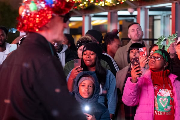 People shoot photos as the Christmas parade begins at Atlantic Station in Atlanta on Saturday, Nov. 23, 2024.   Ben Gray for the Atlanta Journal-Constitution