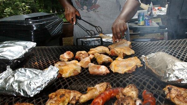 030704 - ATLANTA, GA -- 39 yr. old Janice Sims Scott (cq) of Lithonia has two reasons to celebrate: the Fourth of July and family. The Sims family had relatives to come to the reunion and Fourth of July celebration from as far away as Chicago and Arkansas. Janice does her part by barbecueing the meat, which they had in abundance. She's at one of the pavilions at Stone Mountain Park. (CHARLOTTE B. TEAGLE/AJC staff)