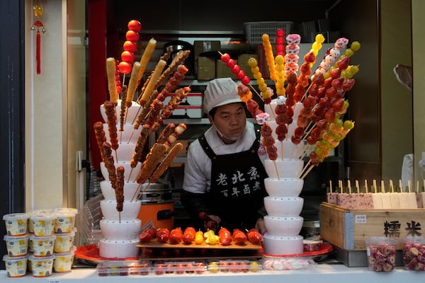 A vendor prepares candied fruits at a shop ahead of the National People's Congress in Beijing, on Feb. 21, 2025. (AP Photo/Ng Han Guan)