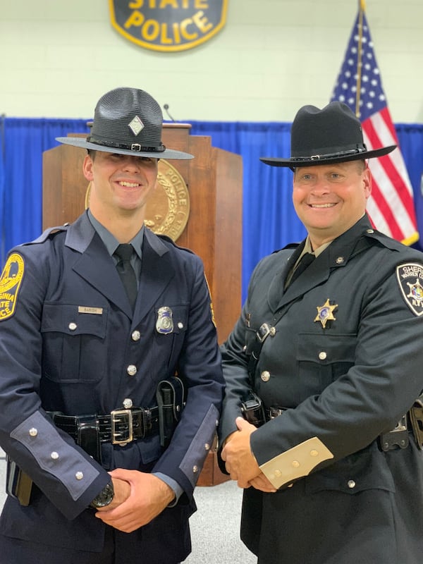 Jim Banish (right) stands with his son, Domanic, during Domanic's graduation from the police academy in 2019. (Courtesy)